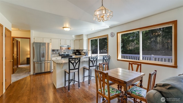 dining area with dark wood finished floors and a notable chandelier