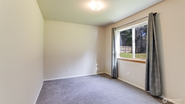 empty room featuring carpet and baseboards