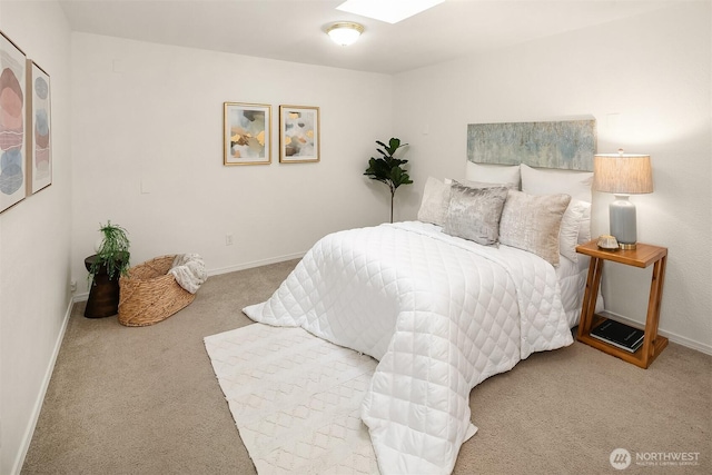 bedroom with a skylight, carpet flooring, and baseboards