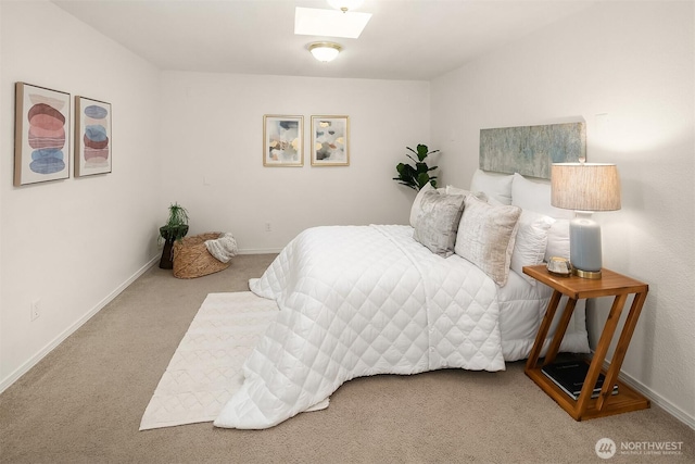 carpeted bedroom with a skylight and baseboards