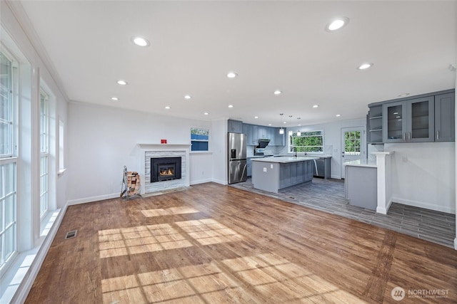 unfurnished living room with a stone fireplace, light wood-style flooring, and recessed lighting