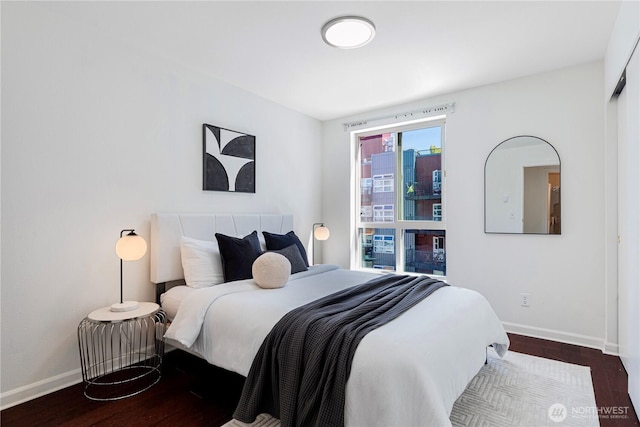 bedroom featuring dark wood-style floors and baseboards