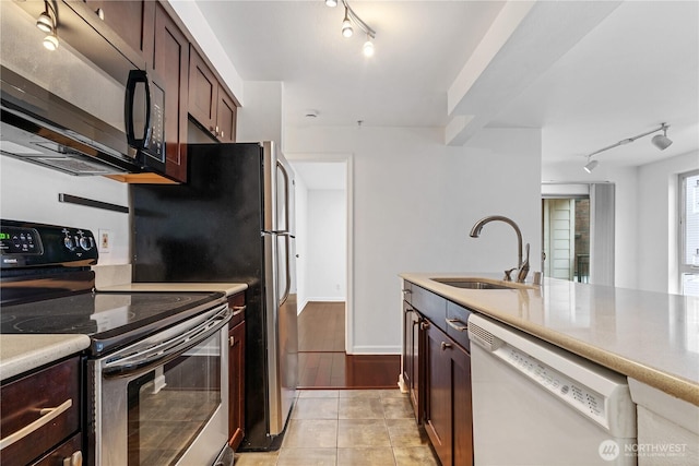 kitchen with electric range, dishwasher, light countertops, black microwave, and a sink