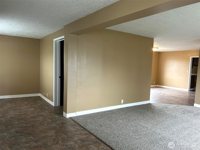 unfurnished room with a textured ceiling and baseboards