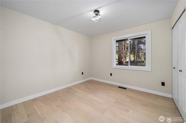 unfurnished bedroom featuring light hardwood / wood-style floors and a closet