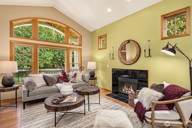 living area with recessed lighting, a fireplace, wood finished floors, baseboards, and vaulted ceiling