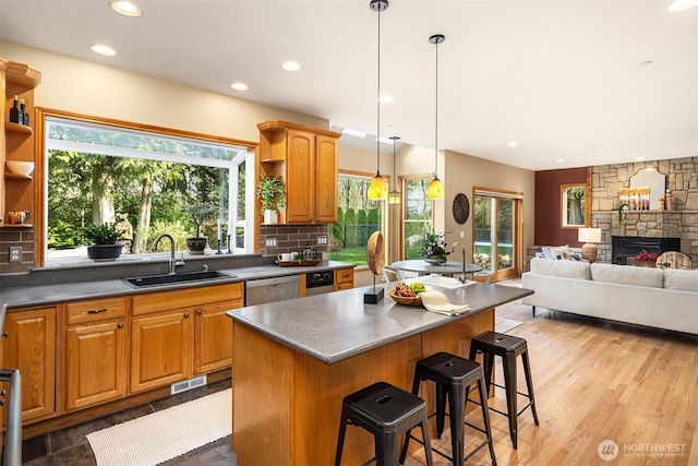 kitchen featuring open shelves, stainless steel dishwasher, a sink, and visible vents