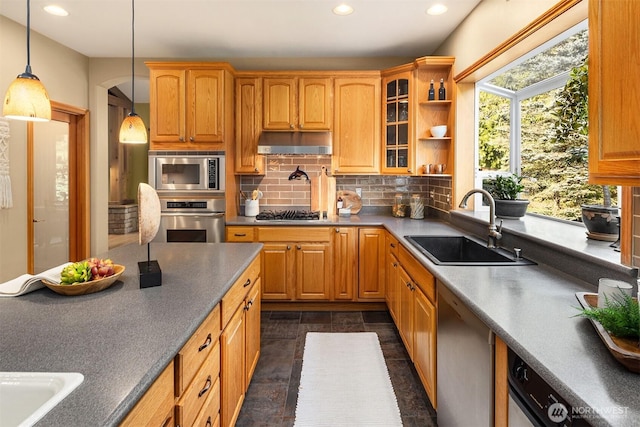 kitchen with a sink, stainless steel appliances, under cabinet range hood, backsplash, and recessed lighting