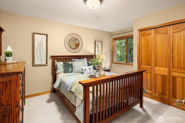 carpeted bedroom featuring baseboards and a closet