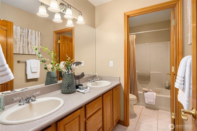 bathroom with tile patterned flooring, a sink, toilet, and double vanity