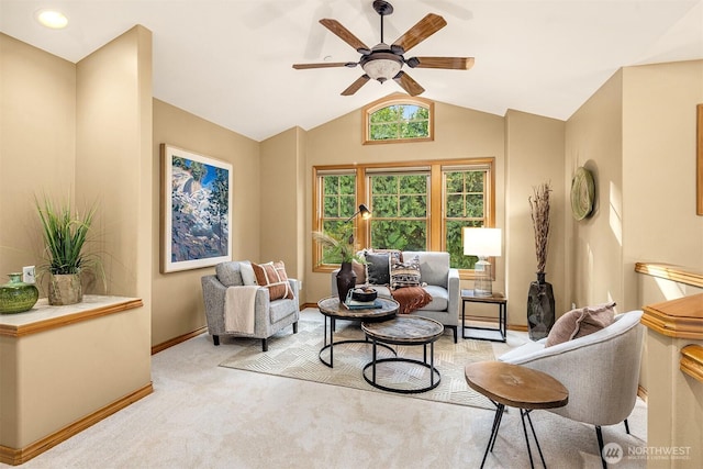 living room featuring lofted ceiling, ceiling fan, baseboards, and light colored carpet