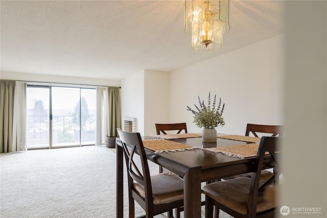 carpeted dining room with a notable chandelier