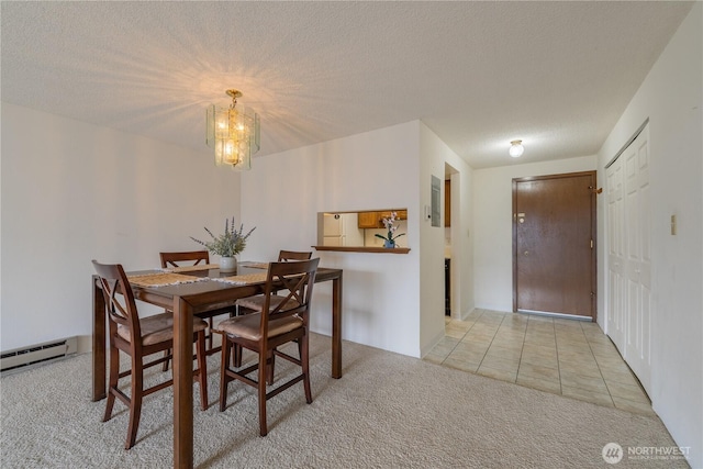 carpeted dining space featuring an inviting chandelier, baseboard heating, a textured ceiling, and tile patterned floors