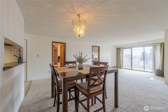 carpeted dining space with a textured ceiling and a notable chandelier