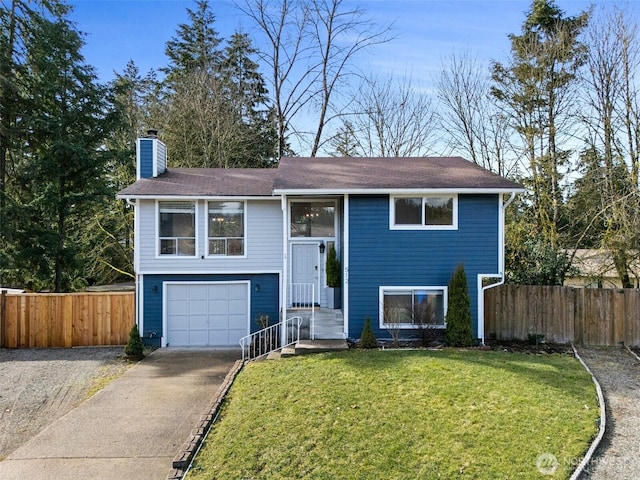 split foyer home featuring concrete driveway, a chimney, an attached garage, fence, and a front yard