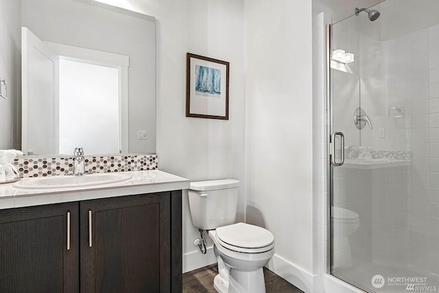 bathroom with backsplash, vanity, an enclosed shower, toilet, and hardwood / wood-style flooring