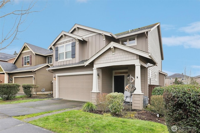 craftsman-style home featuring a garage, aphalt driveway, and board and batten siding