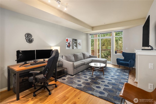 home office featuring baseboards and wood finished floors