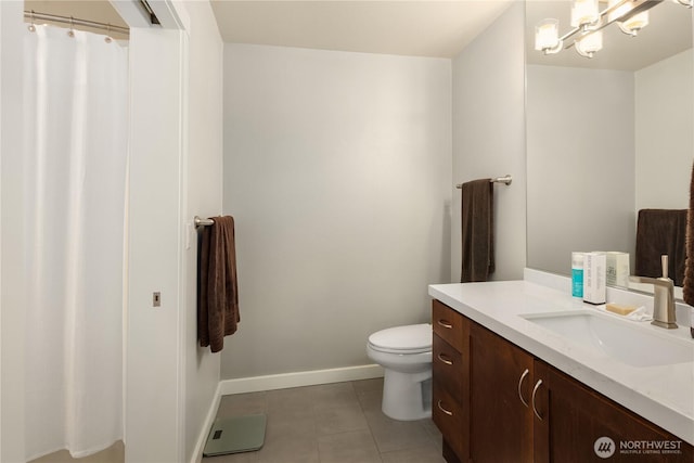 bathroom with tile patterned flooring, toilet, vanity, baseboards, and an inviting chandelier