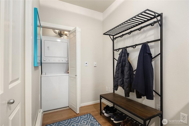 mudroom with stacked washer / dryer, a baseboard radiator, wood finished floors, and baseboards