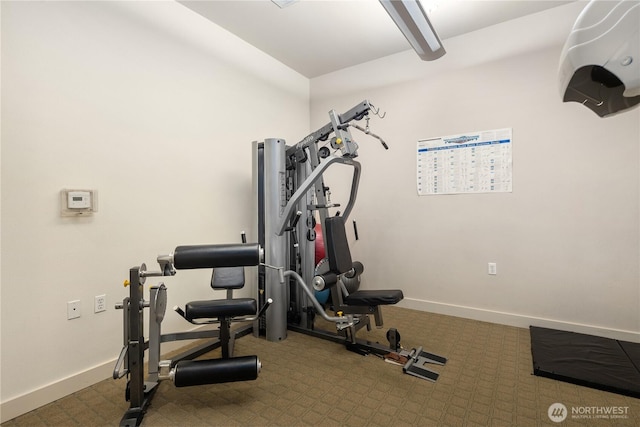 exercise room with carpet and baseboards