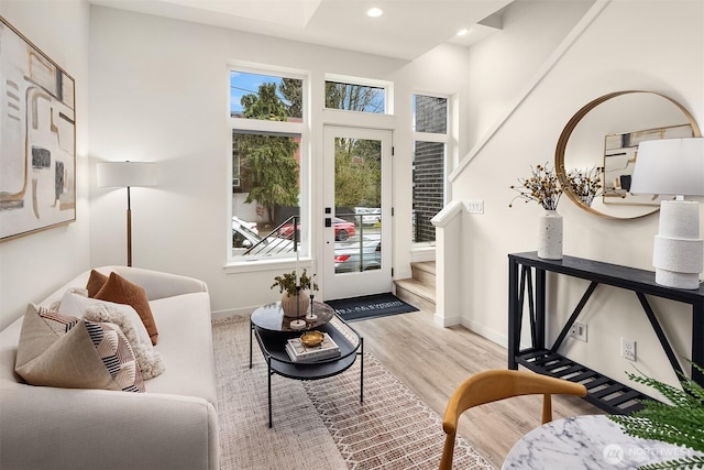 living area with stairs, recessed lighting, wood finished floors, and baseboards