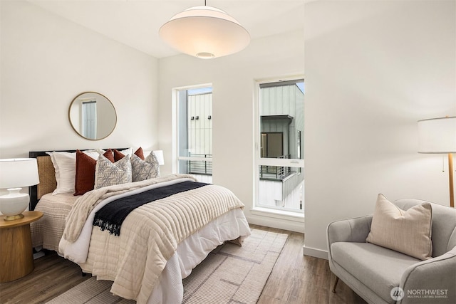 bedroom with wood finished floors and baseboards