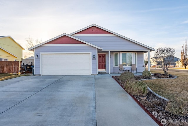 view of front facade with a porch, concrete driveway, an attached garage, and fence