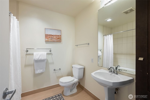 full bath with baseboards, visible vents, toilet, wood finished floors, and a sink