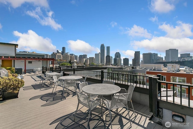 deck with a view of city and outdoor dining space