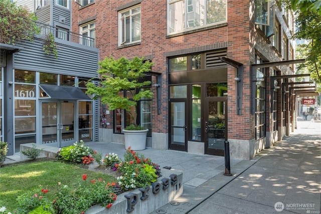 property entrance featuring french doors and brick siding