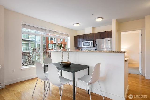 dining room with baseboards and light wood-style floors