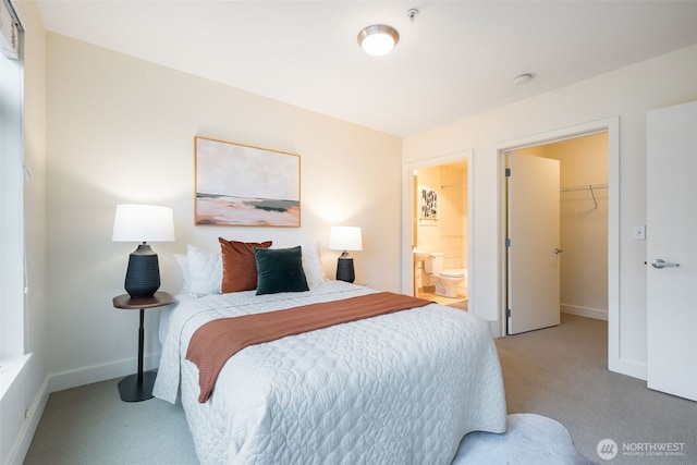 carpeted bedroom with a spacious closet, baseboards, a closet, and ensuite bathroom