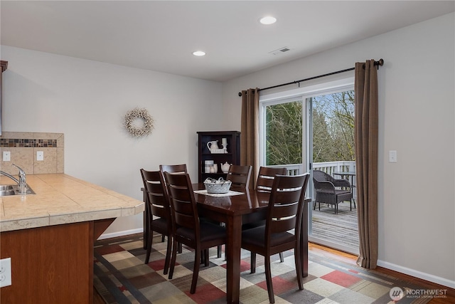 dining space featuring baseboards, dark wood-style flooring, visible vents, and recessed lighting