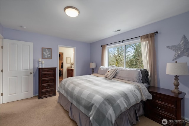 bedroom with light colored carpet, visible vents, and connected bathroom