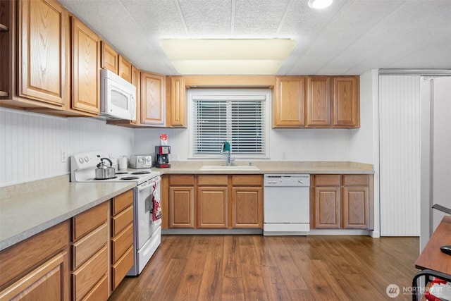 kitchen with white appliances, sink, dark hardwood / wood-style flooring, and a textured ceiling