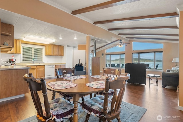 dining area with ceiling fan, vaulted ceiling with beams, dark wood-type flooring, and sink