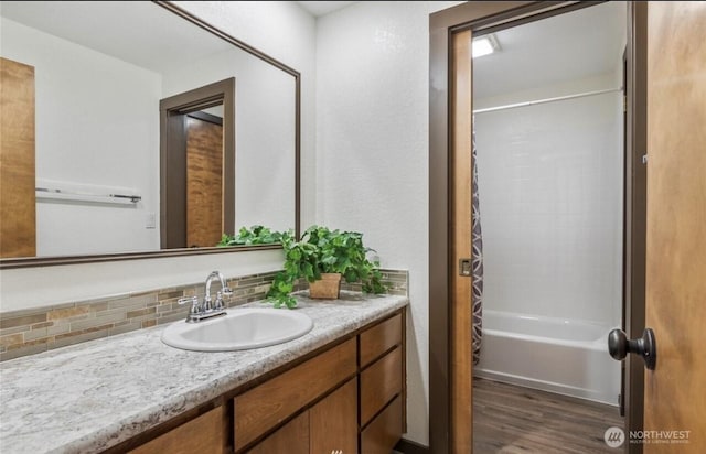 bathroom featuring decorative backsplash, vanity, shower / bath combo with shower curtain, and hardwood / wood-style floors