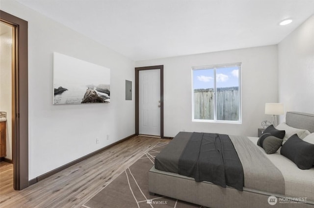 bedroom featuring electric panel and wood-type flooring