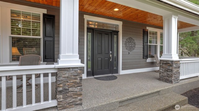 property entrance featuring stone siding and a porch