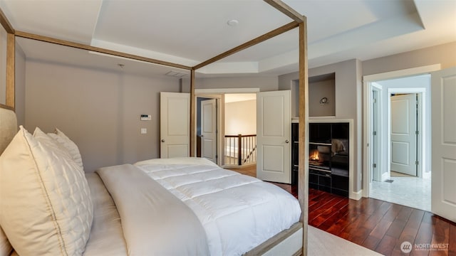 bedroom featuring wood finished floors and a raised ceiling