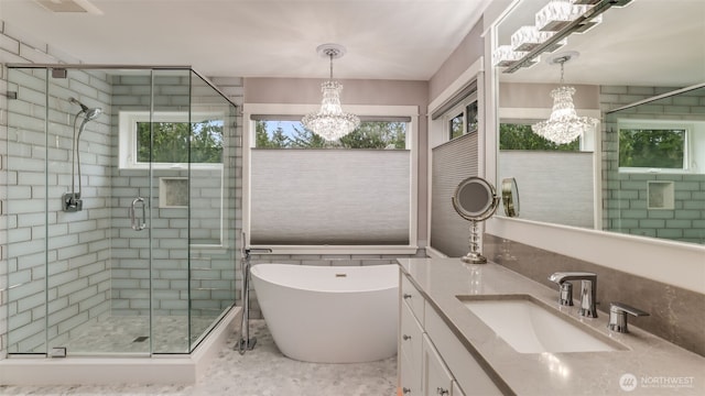 full bath with a stall shower, a chandelier, a freestanding bath, and vanity