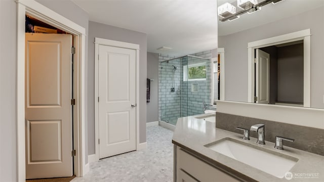 bathroom featuring a shower stall, baseboards, and vanity