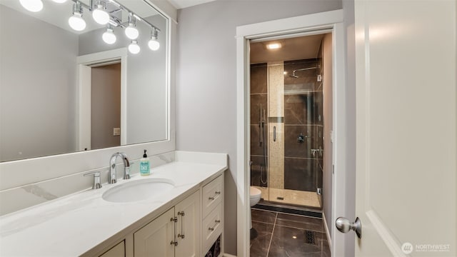 bathroom featuring toilet, a stall shower, and vanity