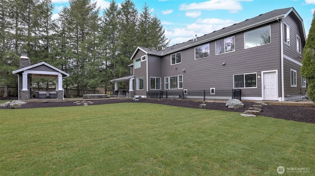 rear view of property with a patio, fence, a yard, a gazebo, and a hot tub