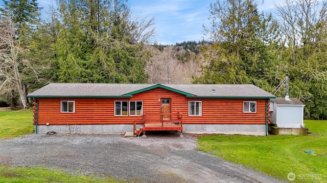 cabin featuring a front yard and a view of trees