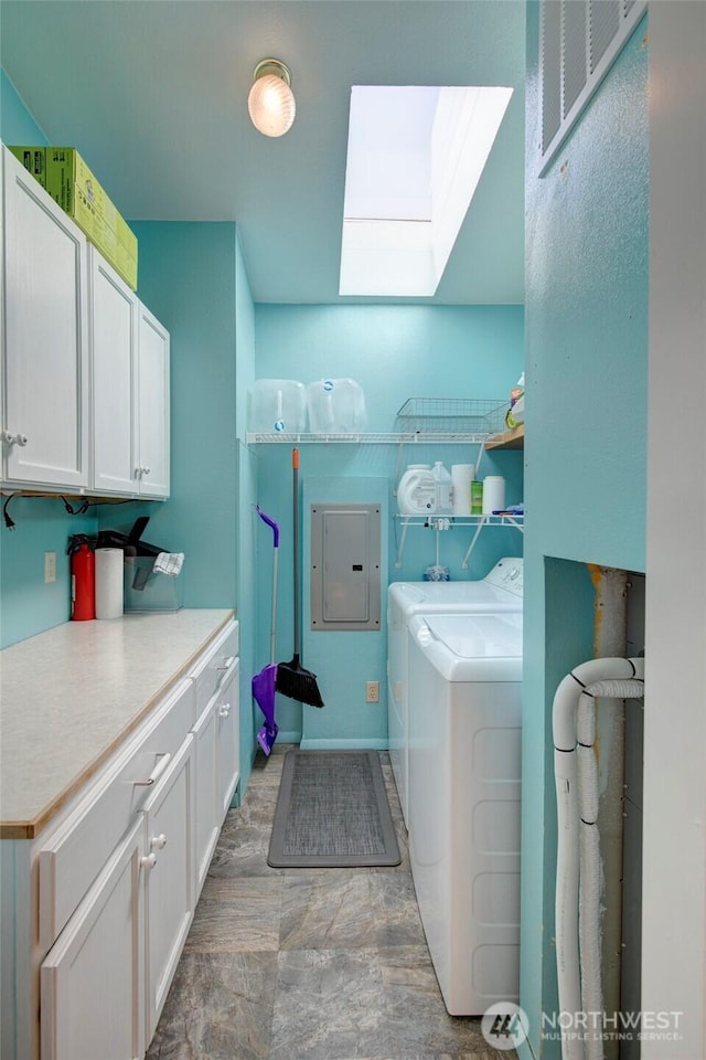 laundry area with a skylight, washing machine and dryer, electric panel, and cabinet space