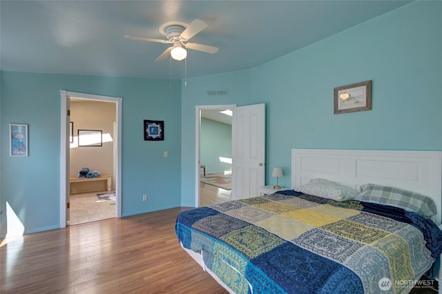 bedroom with ceiling fan, wood finished floors, visible vents, and baseboards