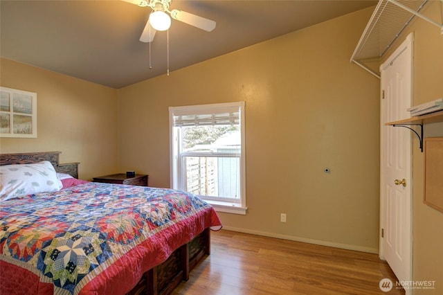 bedroom with lofted ceiling, light wood-style flooring, baseboards, and a ceiling fan