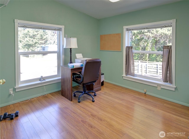 office featuring light wood-style floors, vaulted ceiling, and baseboards